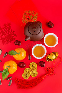 红色金元宝摄影照片_新年春节桔子茶水红色背景上摆放
