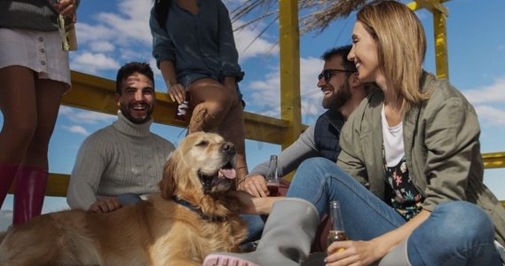 秋天，快乐的朋友们在海滩小屋玩耍，喝着啤酒
