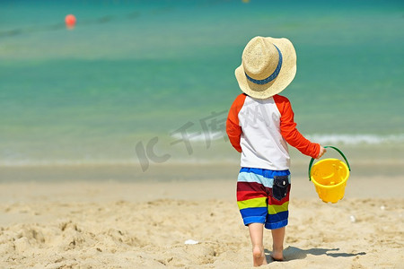 两岁小孩在沙滩上玩耍.海洋婚纱写真