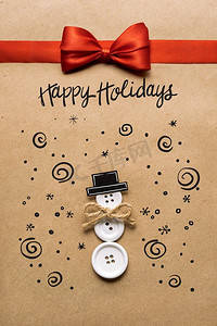 棕色背景用纸做的雪人的创意照片。