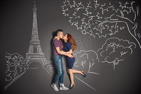 愉快的情人节一对浪漫夫妇的爱情故事概念在巴黎亲吻在反对粉笔画背景的艾菲尔铁塔下。