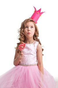 美丽的小糖果公主女孩在冠拿着大粉红色心形棒棒糖。女孩在冠持有心棒棒糖