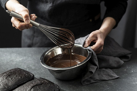高卡路里摄影照片_高角度糕点厨师准备巧克力蛋糕