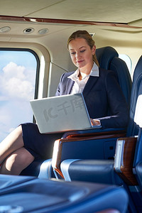 女商人工作在笔记本电脑在直升机舱在飞行期间