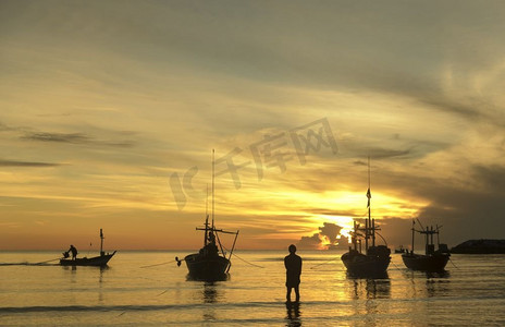 日出时，有船和渔夫的早晨海洋生活