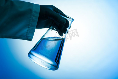 锥形烧瓶摄影照片_手工实验室玻璃中装有绿色液体的圆锥形烧瓶。锥形烧瓶