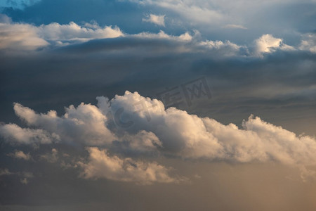 落日天空背景摄影照片_夏季落日天空中令人惊叹的积雨云风暴和雨云的形成，具有戏剧性的喜怒无常的颜色和纹理