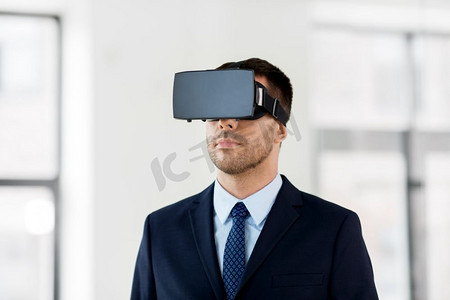 虚拟现实现实摄影照片_商业，技术和增强现实概念—商人与虚拟现实耳机在办公室。商人在办公室与虚拟现实耳机