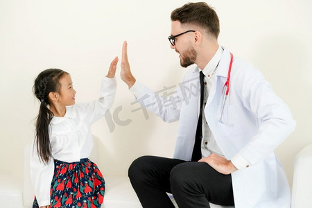 不怕吃苦摄影照片_小孩子到医院的办公室看病。这孩子很开心，也不怕医生。医疗和儿童保健概念。