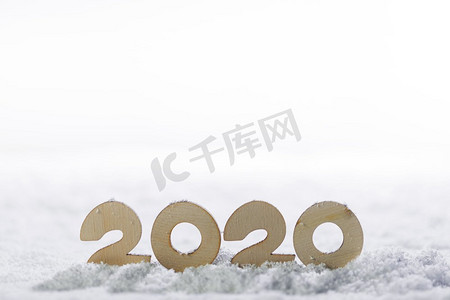 喜庆海报背景摄影照片_2020新年设计理念。木制2020新年水平模板上的雪隔离在白色的背景。2020雪上新年