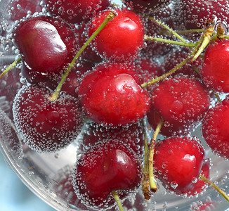 水果鸡尾酒摄影照片_甜樱桃和泡泡在水中