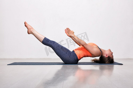 美丽的运动健身瑜伽女子练习瑜伽体式，四肢向上抬起的腿姿势。女子练习瑜伽体式