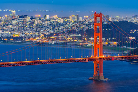 亮金色建筑摄影照片_金门大桥位于美国加利福尼亚州旧金山西海岸，太平洋西海岸，夕阳西下。金门大桥夕阳