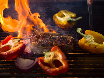 俺炭火烤肉摄影照片_美味的烤肉牛排配蔬菜。烤肉架上的蔬菜牛排