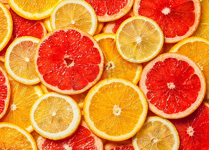 五颜六色的柑橘类水果—柠檬，橙，葡萄柚—切片背景.五颜六色的柑橘水果片 