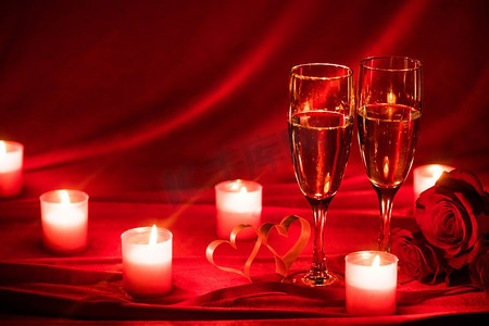 情人玫瑰摄影照片_情人节背景与香槟杯玫瑰蜡烛和心。香槟杯和玫瑰