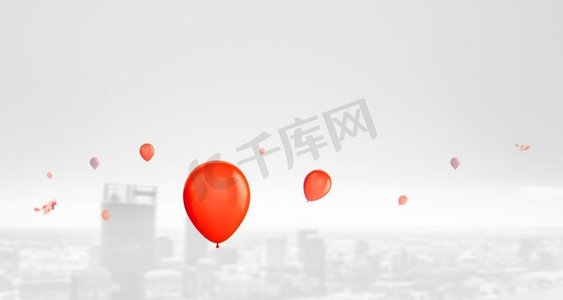 红色的气球和飞机在白色柔和的城市背景下在天空中飞行。城市上空飞过的红色气球和飞机