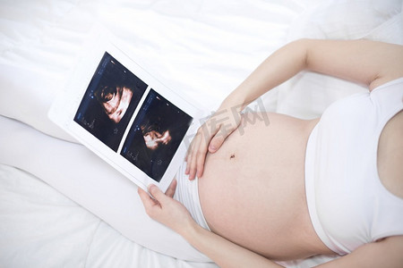 近拍孕妇举行超声波扫描在她的肚子