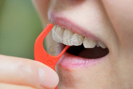 女人用正畸牙线清洁牙齿的细节