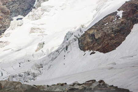 攀爬雪山摄影照片_在高大的雪山中攀登