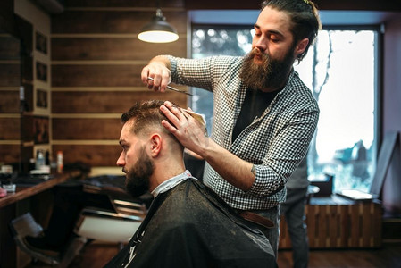 大胡子理发师用剪刀剪男客户的发型