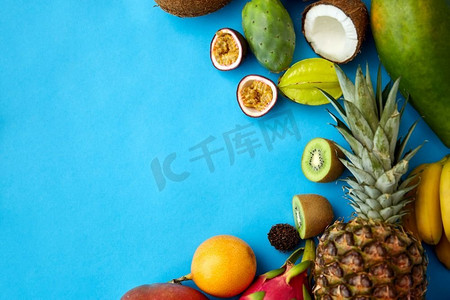 食物，夏季和健康饮食概念—不同的异国情调的水果在蓝色背景。不同的外来水果在蓝色背景