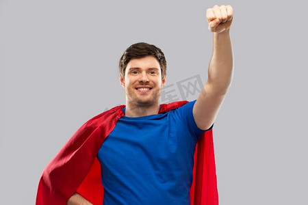 超级力量和人的概念—在灰色背景的红色超级英雄斗篷快乐的年轻人人在红色超级英雄斗篷在灰色背景