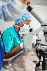 亚洲印度女性医学或科学家使用显微镜在研究实验室或实验室与她的同事