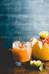 杯柑橘汁混合在桌子上在黑暗的墙壁背景。维生素C饮料健康的生活方式