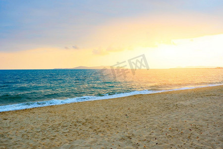 沙滩上的夕阳摄影照片_夏天沙滩上的夕阳，天空是云黄的背景