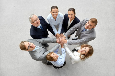 企业、人和团队合作理念—快乐的企业团队堆叠双手。快乐的生意人堆积双手