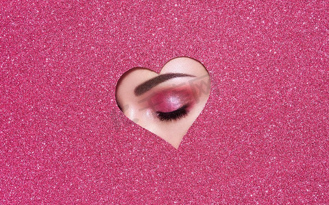 情人节的概念照片。’ Eye of Girl with Festive Pink Makeup纸心在粉红色的背景。情人节情人节