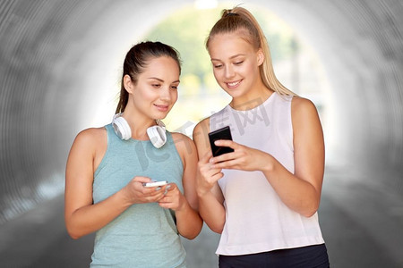 手机app生活摄影照片_健身、运动和健康的生活方式理念-微笑的年轻女性或智能手机的女性朋友。拥有智能手机的女性或女性朋友
