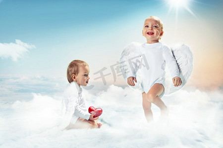 丘比特摄影照片_概念肖像的两个愉快的丘比特在云