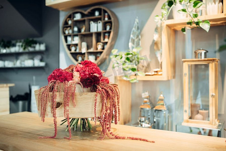 红色花束摄影照片_新鲜的红色花束装饰在桌子上的商店，没有人。精品花卉构图，专业花卉服务
