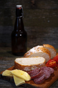 香肠、西红柿、奶酪面包放在木头的背景上。香肠番茄奶酪面包