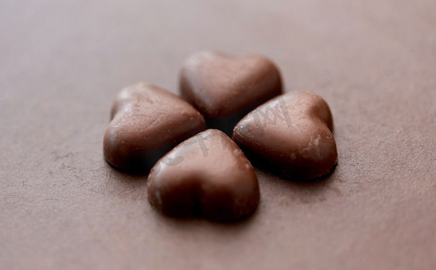 糖果，糖果和食物概念—心形巧克力糖果在棕色背景。心形巧克力糖果