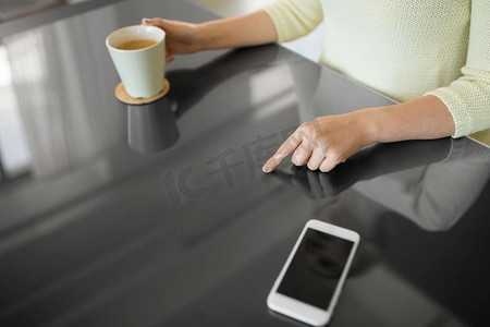 与人连接摄影照片_科技与人的概念-女性使用黑色互动面板喝咖啡的特写。喝咖啡的女人使用黑色互动面板