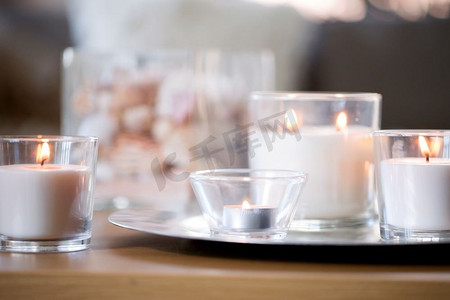 装饰，hygge和舒适的概念—燃烧白色香味蜡烛在托盘在桌子上。燃烧白色香味蜡烛在托盘在桌子上