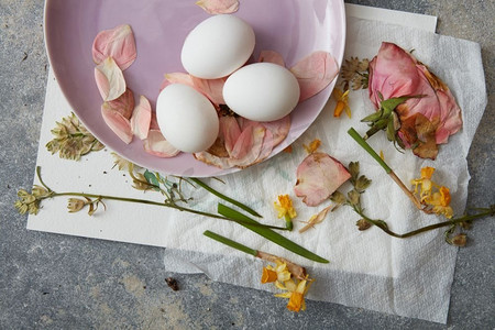 复活节彩蛋与花装饰在石头背景。白鸡蛋干花
