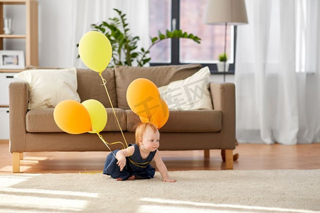 童年，孩子和人的概念—可爱的红头发女婴与气球在家里。可爱的红头发女孩与气球在家里