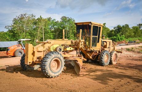 带轮式拖拉机在施工现场工作的现代平地机/黄色平地机道路施工压土机