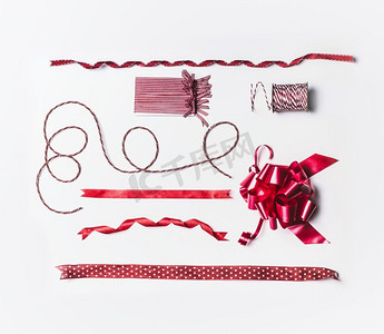 各种圣诞彩带和蝴蝶结，用于装饰和礼品包装，白色背景，俯视，平放