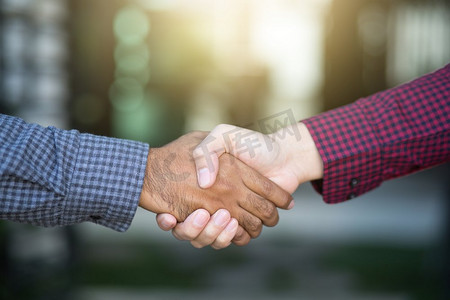 两位同事之间商务握手的特写 红黑格子衬衫手手套