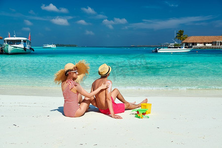 海滩上的一对年轻夫妇。女性在男士S背上涂防晒霜。在马尔代夫度暑假。
