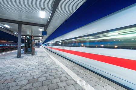 高速列车在火车站行驶,夜间有美丽的照明.地板砖月台