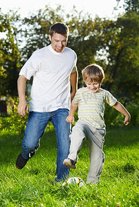 兴高采烈的父子俩在公园里玩足球