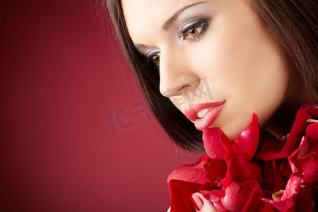 有红色花瓣的迷人女孩的肖像,与世隔绝美女人物特写