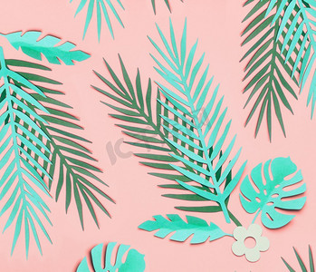 在粉彩粉红色背景，顶视图，平铺设的绿松石绿色热带叶子。创意植物布局