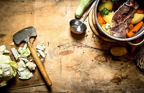 大锅牛肉摄影照片_一大锅牛肉和新鲜蔬菜汤。在木制背景上。一大锅牛肉和新鲜蔬菜汤。